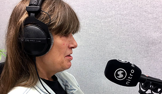 Berit Vegheim med headset foran radiomikrofon