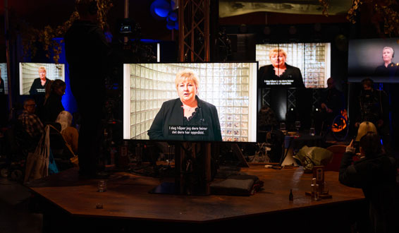 Monitorer som viser Erna Solbergs videohilsen