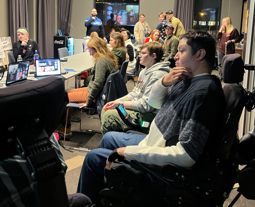 Ei klynge av paneldeltakarar, camp-freedom-deltakarar, Uloba-tilsette og assistentar inne på eit møteron på Quality Hotel River Station i Drammen.