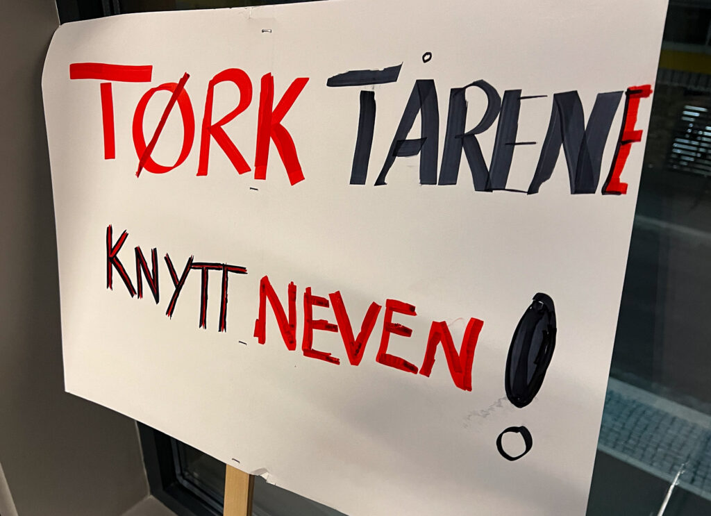 Plakat med påskrifta "Tørk tårene, knytt neven!"