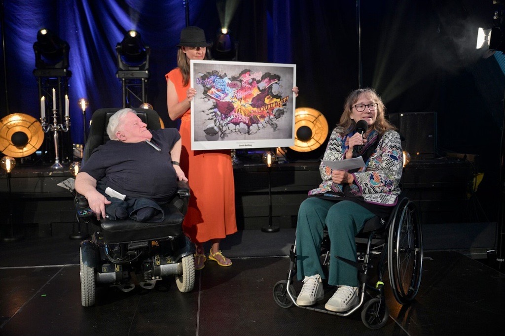 Jamie Bolling på scenen under Stolt Natt 8. juni på SALT. Ved siden av henne står festivalsjef Anneth Nielsen med bildet Bolling får sammen med prisen, og Knut Flaaum som presenterte vinneren.
