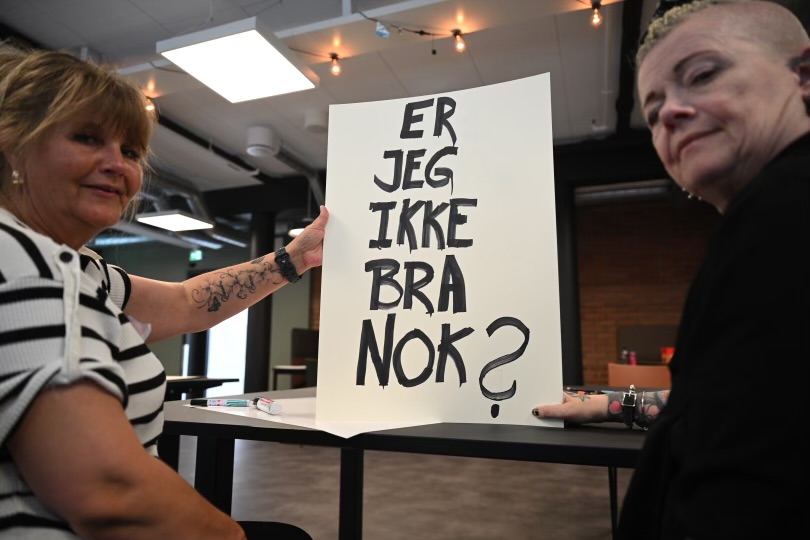 Popcorn og paroler her med Helle Viv og assistent. På parolen står det Jeg er ikke bra nok